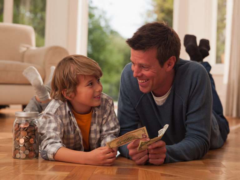 Father and son with paper currency