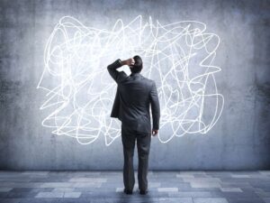 Confused businessman staring at scribble on wall Confused businessman staring at scribble on wall