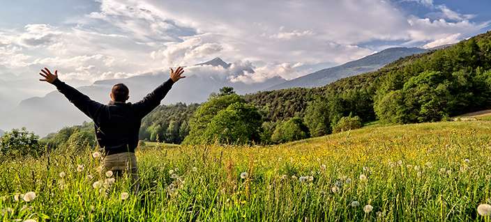 One man with arms outstretched in alpine landscape horizontal One man with arms outstretched in alpine landscape horizontal